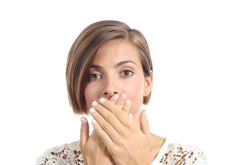 Woman covering her mouth because bad breath isolated on a white background