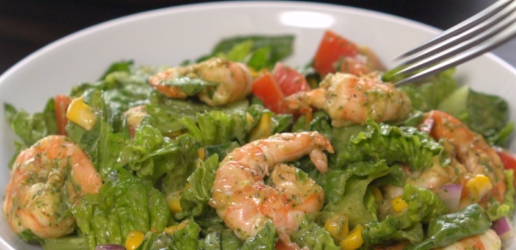 Close-up of fork piercing shrimp avocado salad