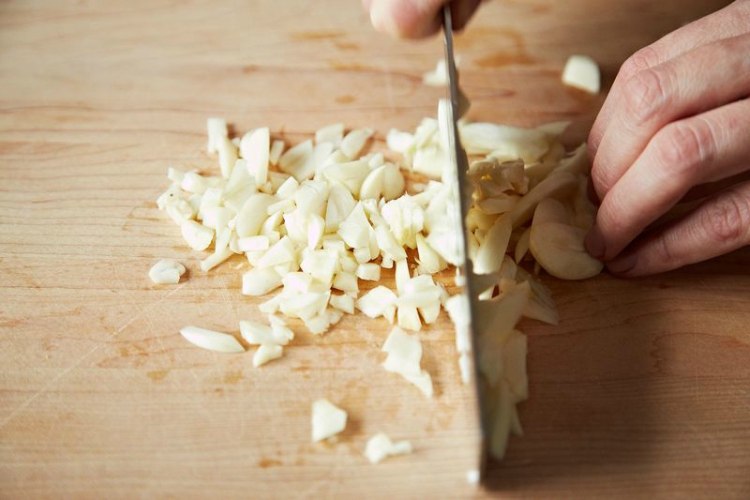 person mincing garlic