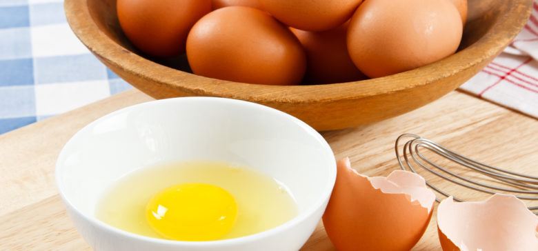 basket of brown eggs with raw egg