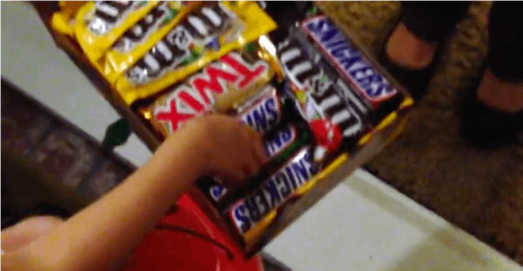 girl grabs a Snickers bar