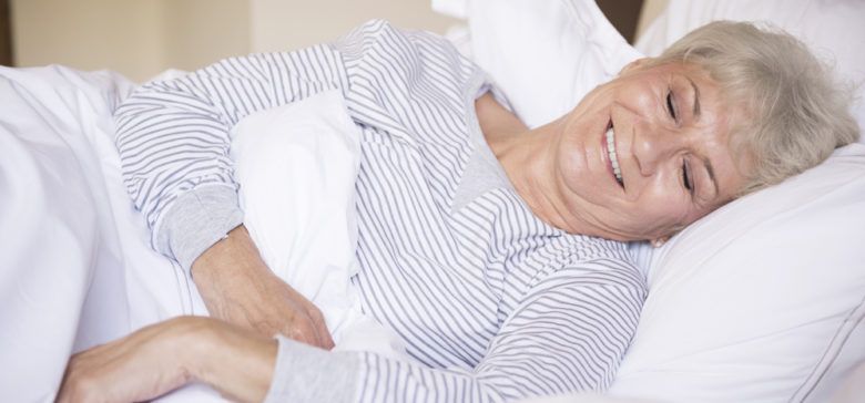 older woman smiling and sleeping