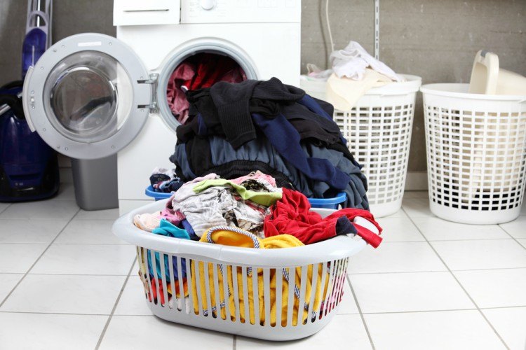 overflowing laundry baskets near washer and dryer