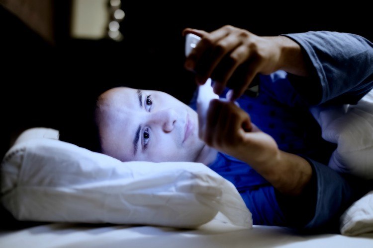Image of guy in the bed with phone.