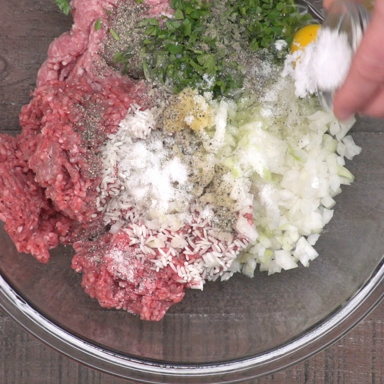 In a large bowl, combine ground beef, pork, onion, garlic, parsley, salt, pepper, egg and rinsed rice