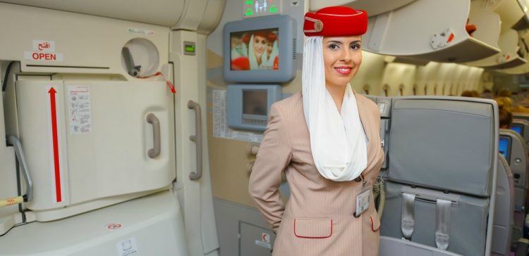 Flight attendant standing with arms behind her back