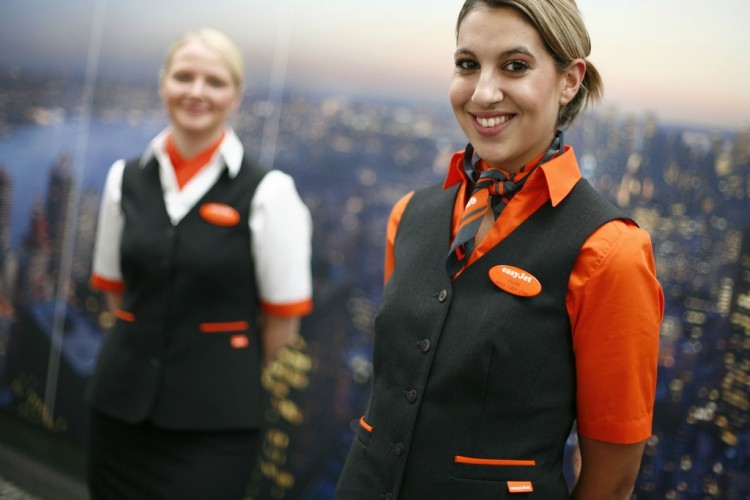 Two flight attendants with arms behind backs
