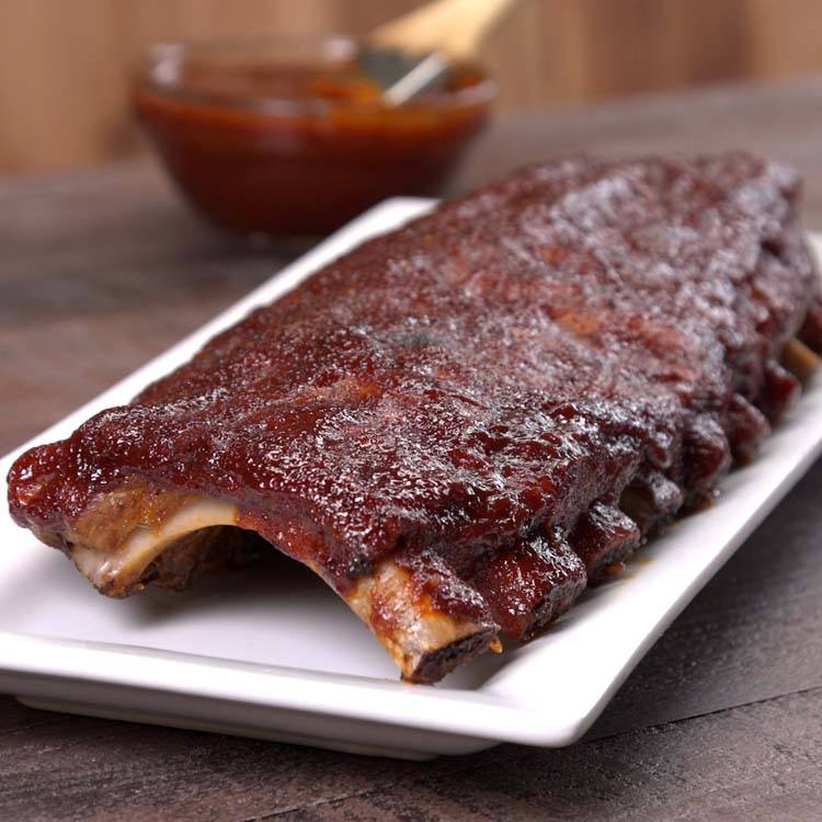Baked BBQ Ribs whole rack with sauce on platter