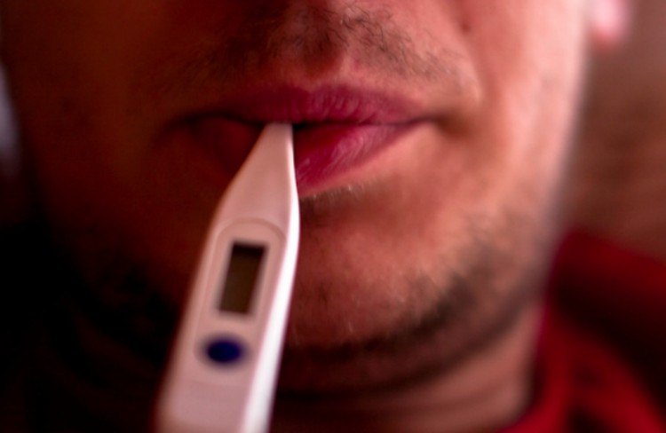 man with thermometer in mouth