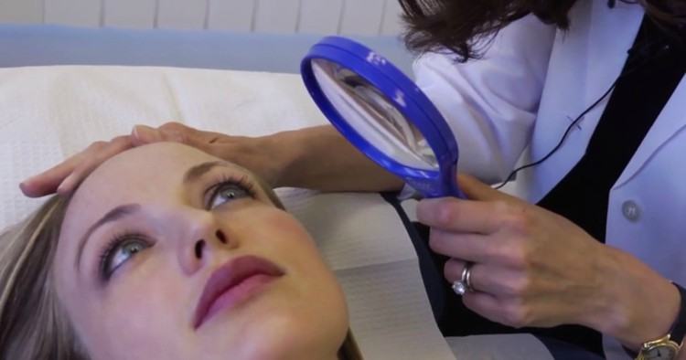 Image of woman having her face examined.