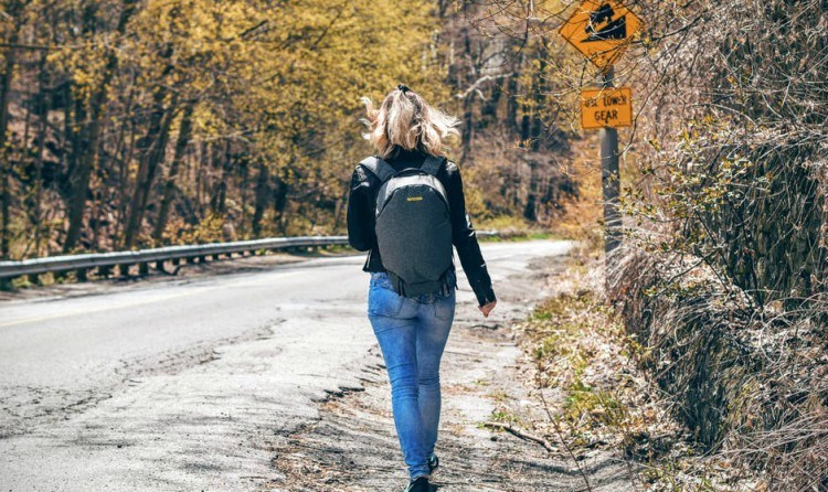woman walks down road wearing tight jeans