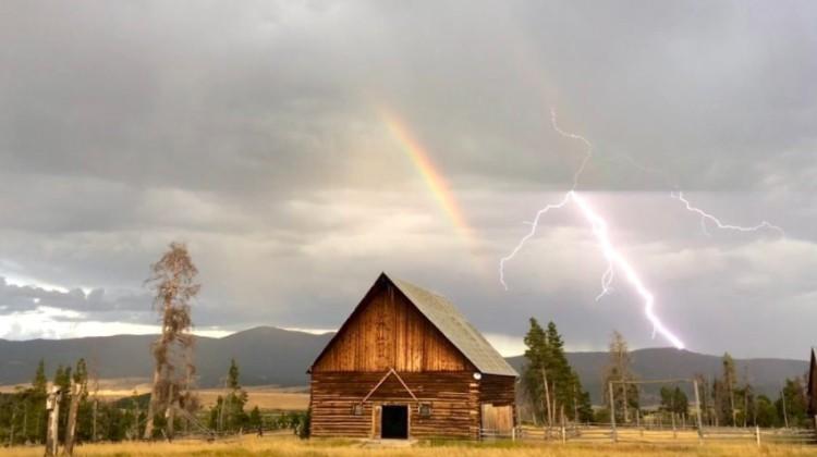 rainbow and lightning bolt behind cabin