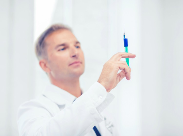 Doctor holding syringe.