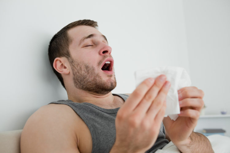 Image of man sneezing