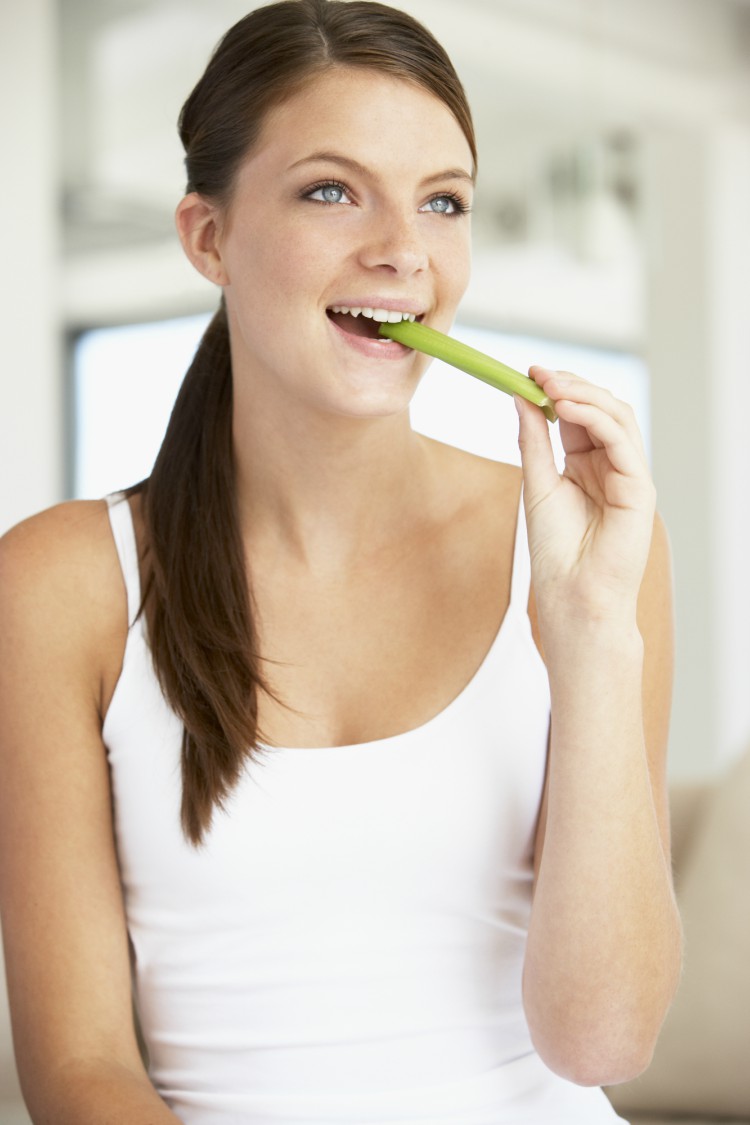 Image of woman eating celery.