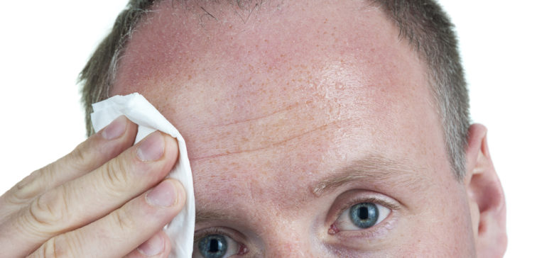 Image of sweaty man wiping forehead