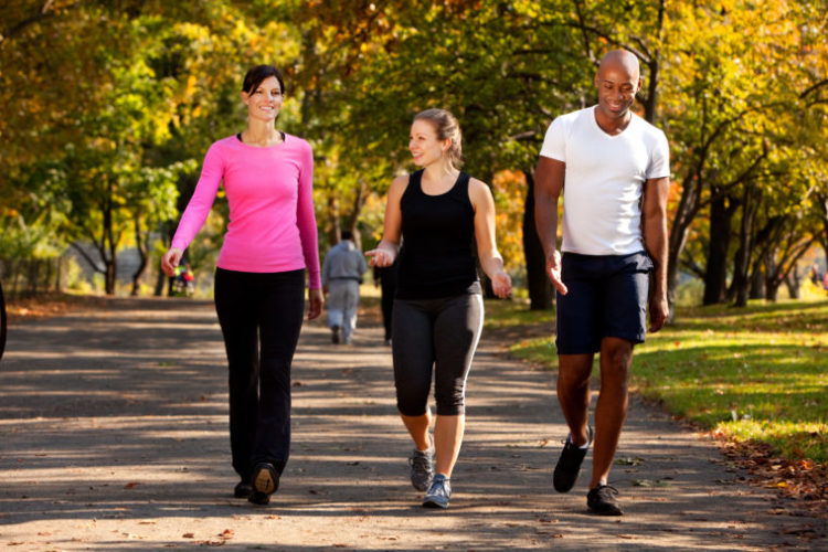 Image of three people walking in a park, getting some exercise