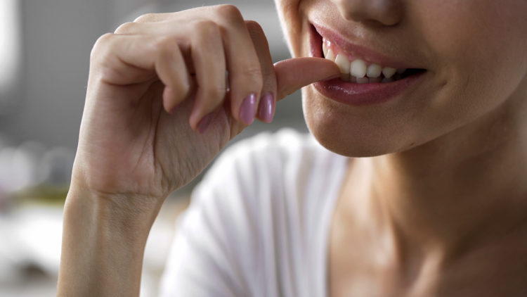 Image of woman biting nails.