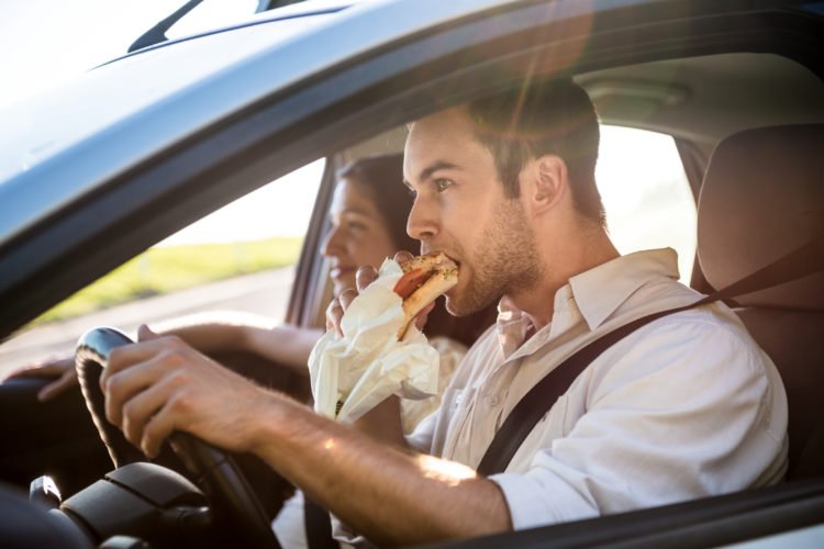 Image of man eating while driving