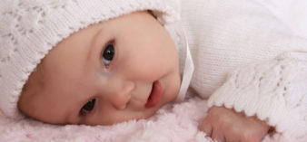 Image of beautiful two month old baby girl wearing a knitted outfit
