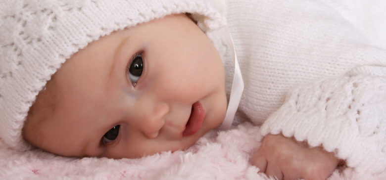 Image of beautiful two month old baby girl wearing a knitted outfit