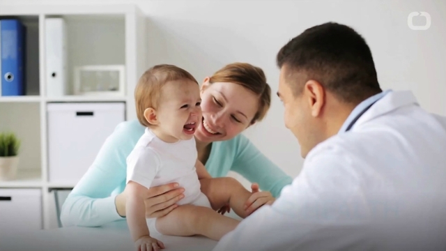 mom laughing with baby and doctor