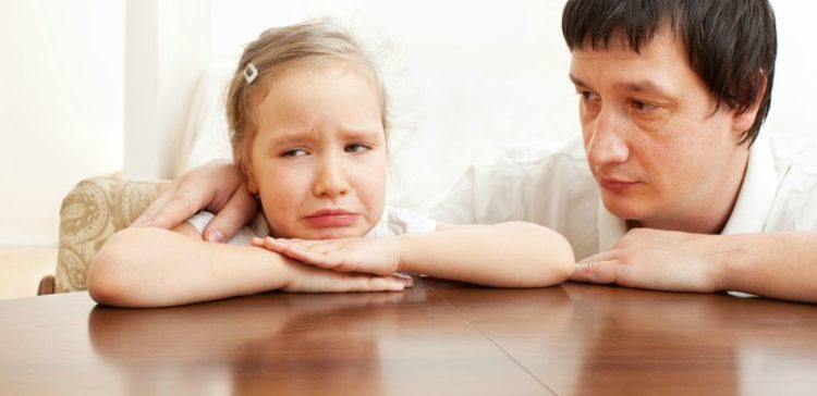 Image of upset little girl and father.