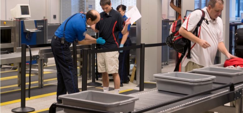 Image of person going through airport security with trays in front vision