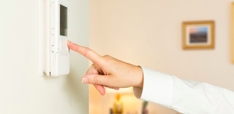 Image of woman touching thermostat