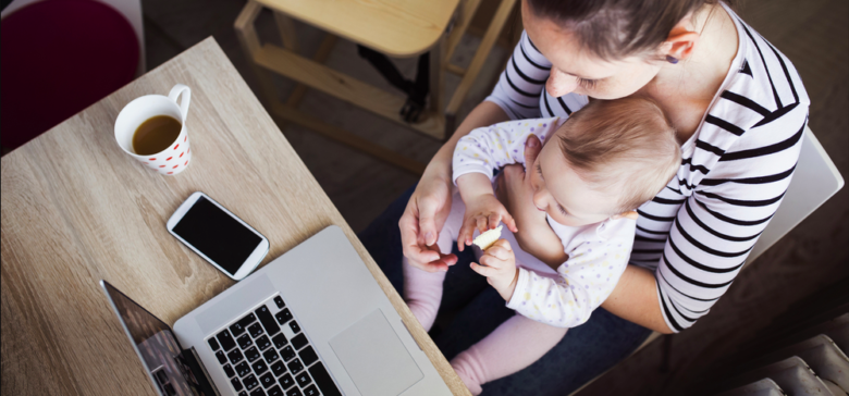 Image of working mom with baby at computer with coffee