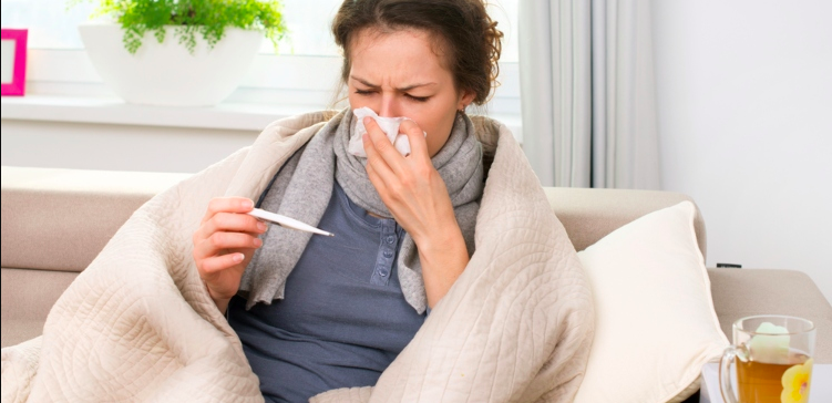 Image of sick woman blowing nose taking temperature