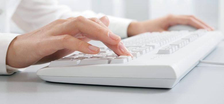 Image of hands touching computer keys during work