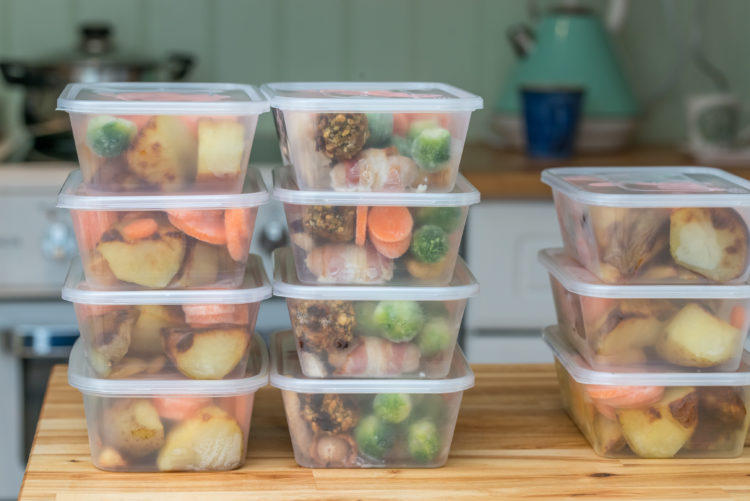 Image of stack of home cooked roast chicken dinners in containers ready to be frozen for later use as quick and easy ready meals.