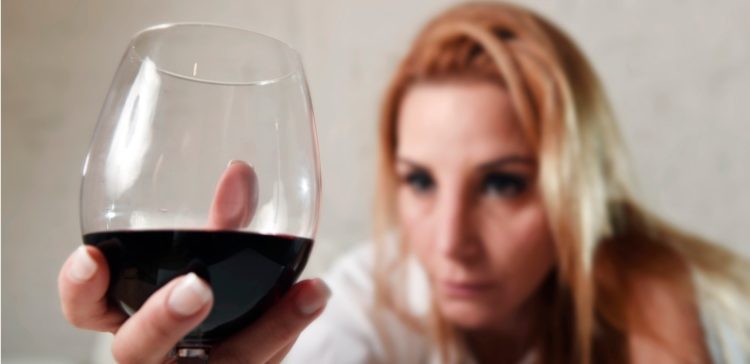Image of woman holding glass of wine.