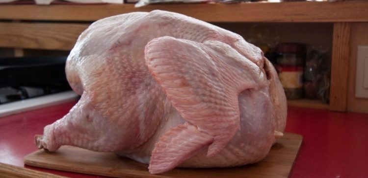 Image of raw turkey on cutting board.