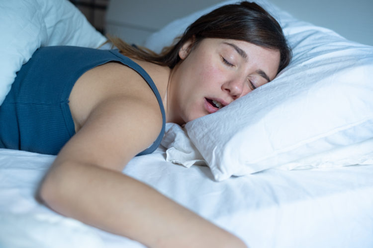 Image of one tired woman snoring in bed