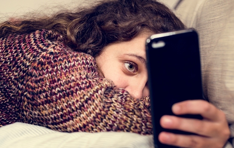 Image of Teenage girl using a smartphone on a bed social media and addiction concept