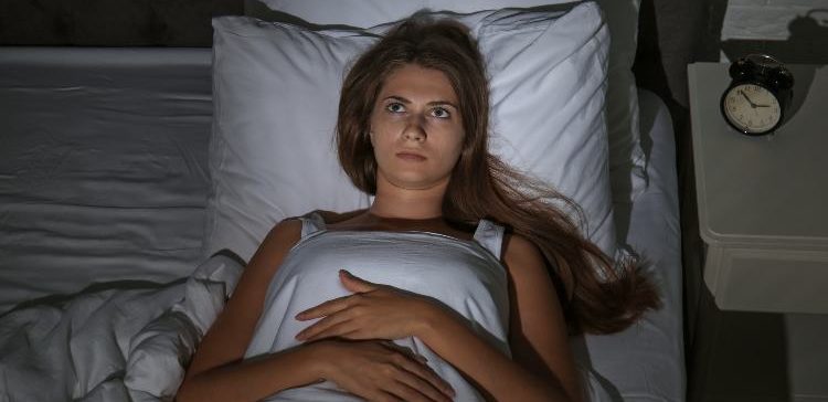 Image of woman awake in bed