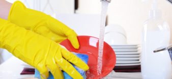 Image of Close up hands of woman washing dishes in kitchen