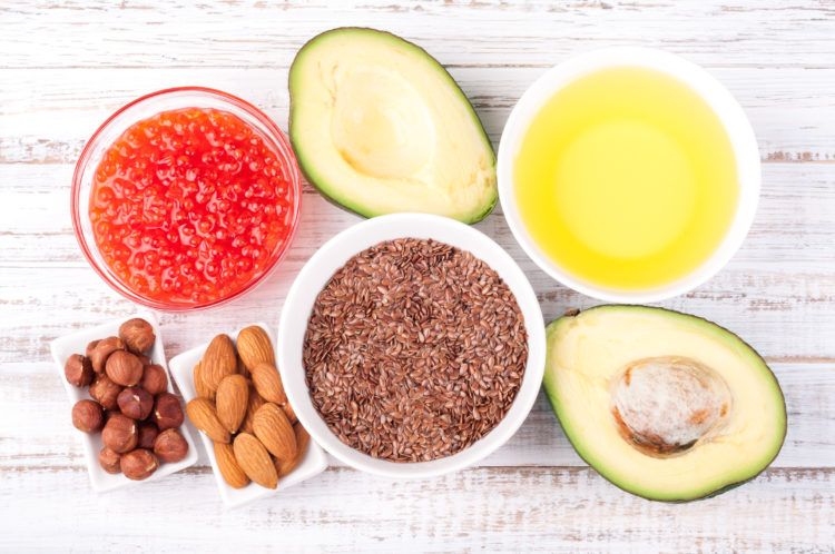 Image of Healthy fats. Sources of omega 3 - avocado, olive oil, red caviar, nuts and flax seed on wooden background. Healthy food concept. Top view