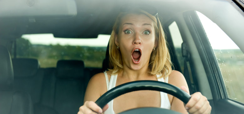 Image of scared woman shouts driving the car - outdoors