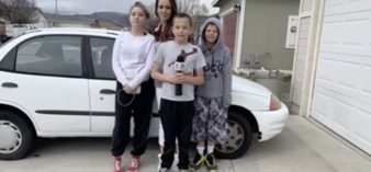 Image of family in front of car