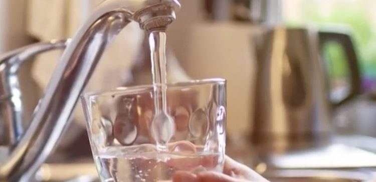Image of person getting glass of tap water.