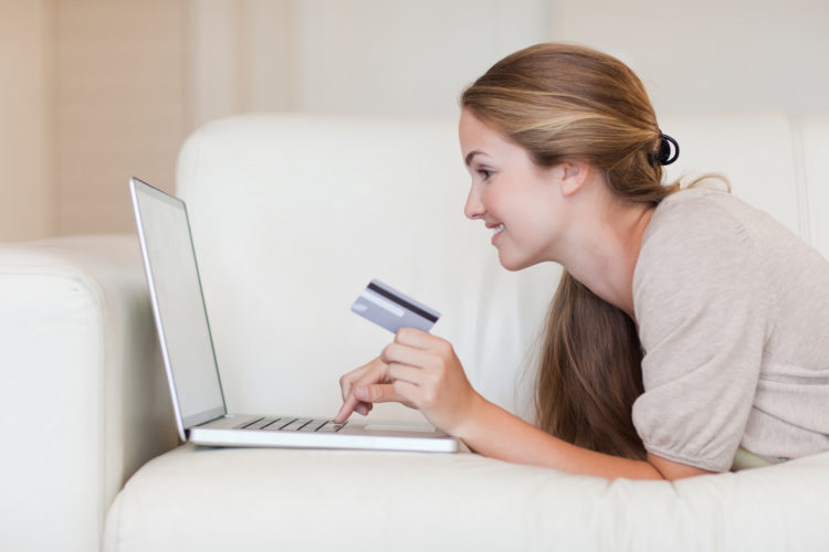 Side view of woman on the sofa shopping online